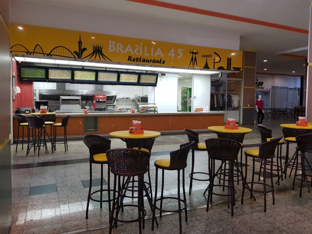 Restaurante do mall do SIA Centro Empresarial com balcão de atendimento, cardápios iluminados e mesas altas